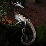 A polished stainless steel and bronze dragon