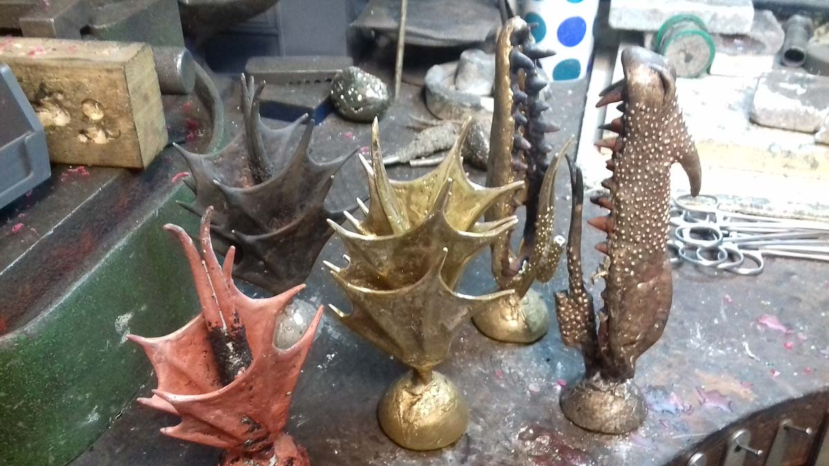 Lost wax cast dragon faces in copper and bronze