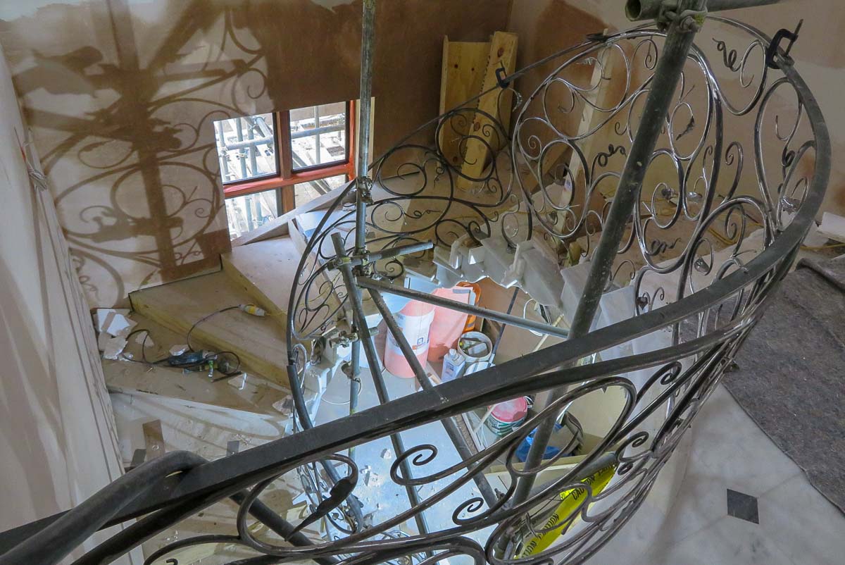 The naturalistic curves of the railings complement the flow of the elliptical marble stairs 
