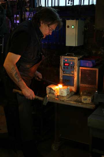 a blacksmith using a 21st century induction forge