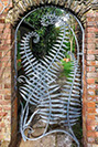 A garden gate designed around fern sculptures and fern detailing